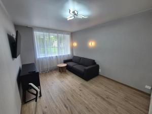 a living room with a couch and a ceiling fan at Like home in Narva