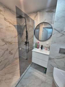a bathroom with a shower and a sink and a mirror at Like home in Narva