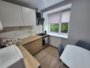 a kitchen with a counter with a stove and a window at Like home in Narva