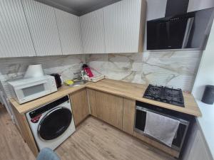 a small kitchen with a microwave and a stove at Like home in Narva +3 photos