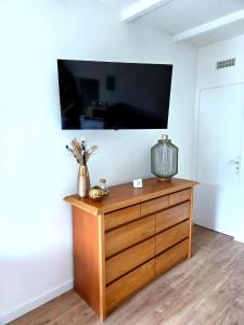 a wooden dresser with a flat screen tv on a wall at Le Sargier in Levens