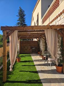 a wooden pergola with a table and a bench at Le Sargier in Levens