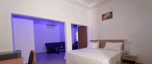 ein Schlafzimmer mit einem weißen Bett in einem Zimmer in der Unterkunft Hotel Koliafo in Aného