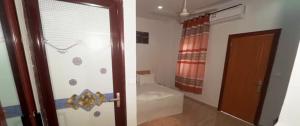 ein Badezimmer mit Tür und ein Zimmer mit Badewanne in der Unterkunft Hotel Koliafo in Aného