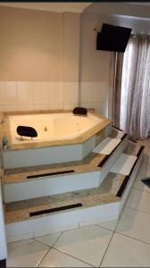 a bath tub sitting inside of a room at Florença Hotel in Quedas do Iguacu +26 photos