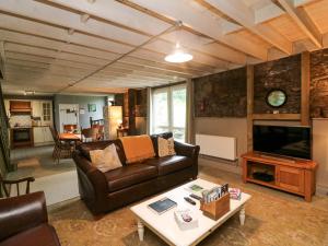 a living room with a couch and a table at Childwall Cottage in Tullagher