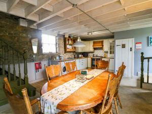 a kitchen and dining room with a wooden table at Childwall Cottage in Tullagher +15 photos