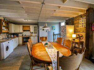 a dining room with a wooden table and chairs at Childwall Cottage in Tullagher