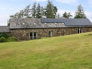 a house with solar panels on top of a field at Childwall Cottage in Tullagher