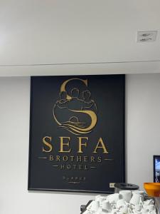 a sign for a hotel on a wall at Hotel sefa brothers in Golem