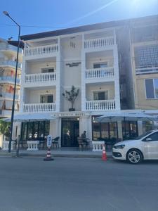 a white car parked in front of a building at Hotel sefa brothers in Golem