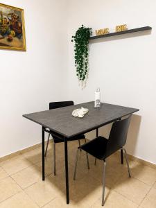 a black table with two chairs and a plant at Norita Alquiler Temporal - Departamento in La Rioja