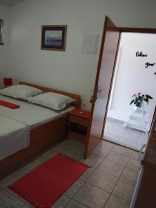 a bedroom with a bed and a door to a patio at Apartmani Zara & Duje in Bibinje