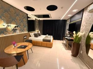 a hotel room with a bed and a table at Hotel Motel Sherwood in Porto Alegre