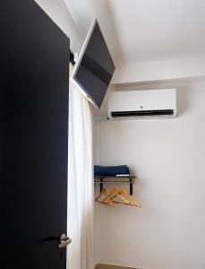 a room with a television and a closet with hangers at Norita Alquiler Temporal - Departamento in La Rioja