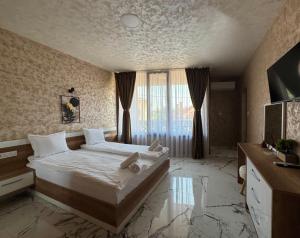 a bedroom with a large bed and a large window at Стаи за гости- Maria Elegance in Pavel Banya