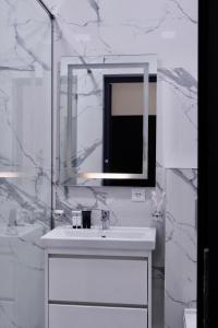 a white bathroom with a sink and a mirror at Lighthouse Hotel in Gyumri +31 photos