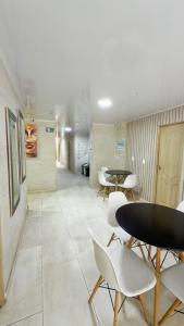 a hallway with two tables and white chairs at Hotel Nakama in Medellín