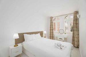 a white bedroom with a white bed and a window at Old Village & Prestige in Vilamoura