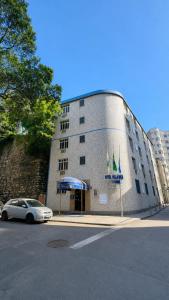a building with a car parked in front of it at Hotel Villa Rica in Rio de Janeiro