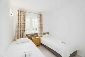 a bedroom with two beds and a window at Old Village & Prestige in Vilamoura