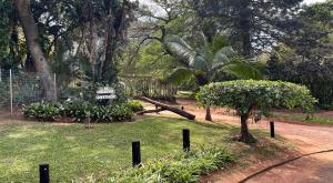 a park with a tree and a sign in the grass at Umlalazi Cottage in Mtunzini