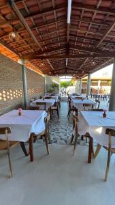 a row of tables and chairs in a restaurant at Pousada Recanto dos Passaros in Aracati