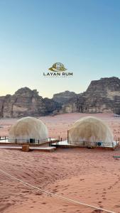 two domes in the desert with mountains in the background at LAYAN RUM LUXURY CAMP & Jeep Tours in Wadi Rum