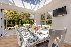 a dining room with a table and chairs and a television at 3 Bed in Reydon oc-brae in Reydon