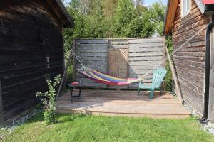 a hammock and a chair sitting on a patio at La Reine in St-Etienne de Bolton +5 photos