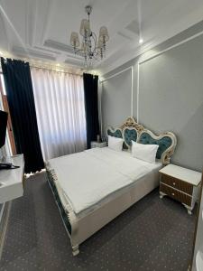 a bedroom with a large bed and a chandelier at Suleyman House Premium in Bukhara