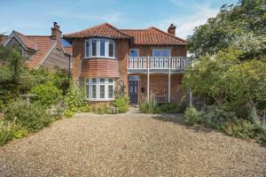 a brick house with a porch and a balcony at 3 Bed in Reydon oc-brae in Reydon