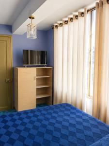 a bedroom with a bed and a tv and a window at Hotel Golden La Paz in Callampaya