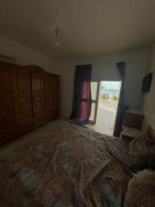 a bedroom with a large bed with a view of the ocean at Maison front de mer 2 in Kelibia