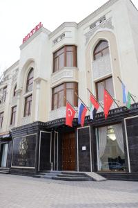 a building with flags on the front of it at Suleyman House Premium in Bukhara
