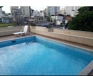 a chair sitting on top of a swimming pool at Apartamento bem localizado in Vitória