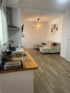 a kitchen and a living room with a couch at Patio de Los Barberos in Valle de Abdalagís