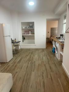 an empty kitchen and living room with wooden floors at Patio de Los Barberos in Valle de Abdalagís