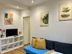 a living room with a blue couch and a tv at Chemin de fer adorable appartement in Gagny