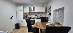 a kitchen with a wooden table and black chairs at COMFY Gemütliche Unterkunft 013 in Ditzingen