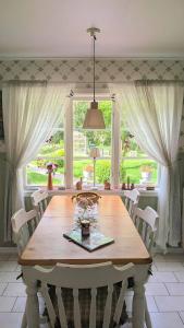 a dining room with a wooden table and a large window at Lindgren Land in Vimmerby