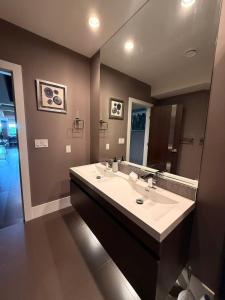 a bathroom with a sink and a large mirror at White Rock Joy Inn in White Rock +22 photos