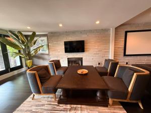 a living room with a table and chairs and a tv at White Rock Joy Inn in White Rock