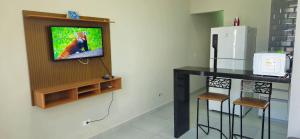 a kitchen with a tv and a counter with stools at Casa 2 Quartos com Ar até 8 Pessoas Jd. Sabiás in Indaiatuba