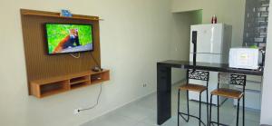 a kitchen with a counter with stools and a refrigerator at Casa 2 Quartos com Ar até 8 Pessoas Jd. Sabiás in Indaiatuba