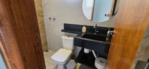 a bathroom with a sink and a toilet and a mirror at Casa 2 Quartos com Ar até 8 Pessoas Jd. Sabiás in Indaiatuba +29 photos