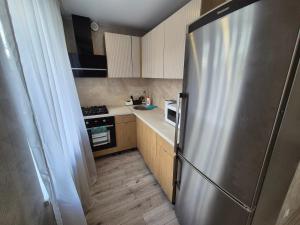 a small kitchen with a stainless steel refrigerator at Apartments near border in Narva