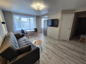 a living room with a couch and a tv and a table at Apartments near border in Narva
