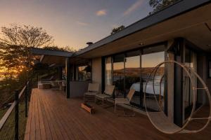 a house with a deck with a bedroom and a bed at Morro Redondo - Bangalôs com vista do lago e da serra in CÃ¡ssia