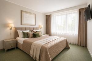a bedroom with a large bed and a window at Apartamentai Palangoje Arune in Palanga